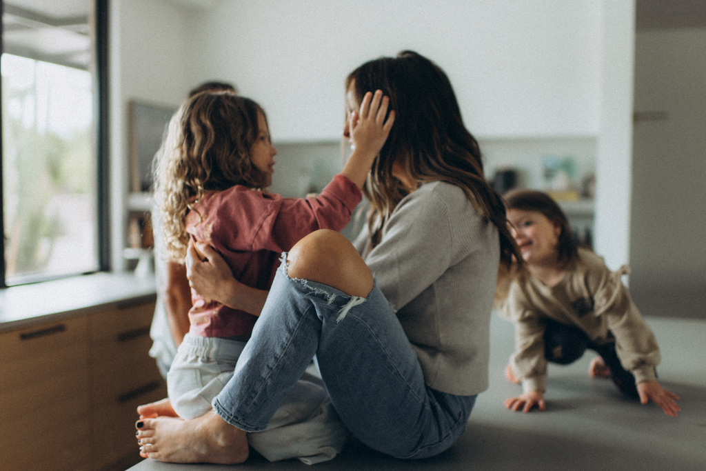 family in kitchen with the kids, mom is talking to daughter on the counter