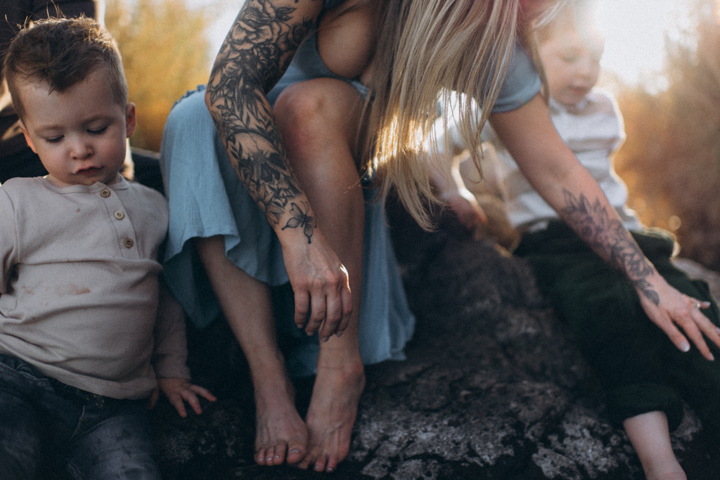 mom leaning over her kids at the river in Arizona in blue dress