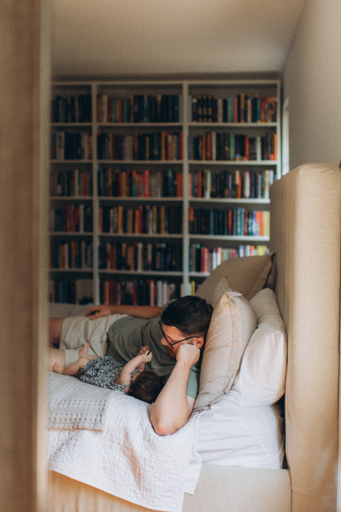 Dad in library with baby girl on the bed