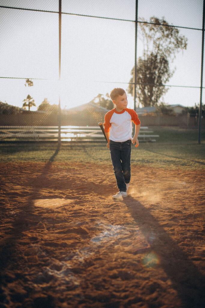 kid walking up to bat during thier their storytelling photo session