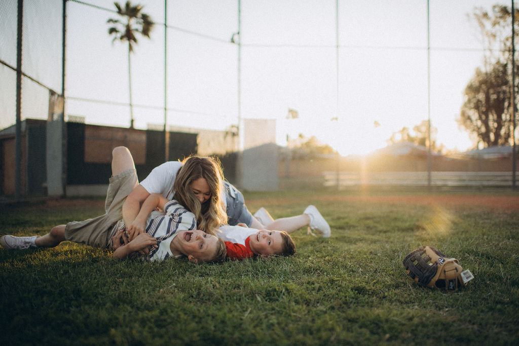 mom tackling boys on the grass
