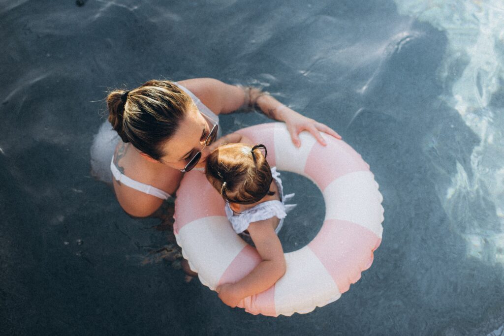 mom kissing daughter in the pool with the retro floatie in arizona
