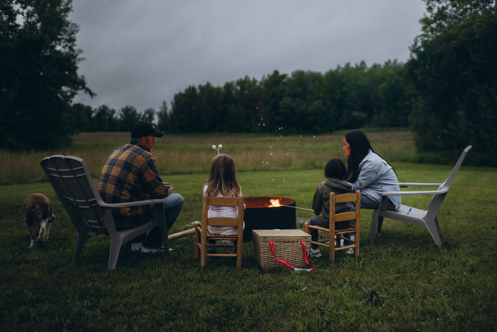 family making s'mores by the fire in their backyard