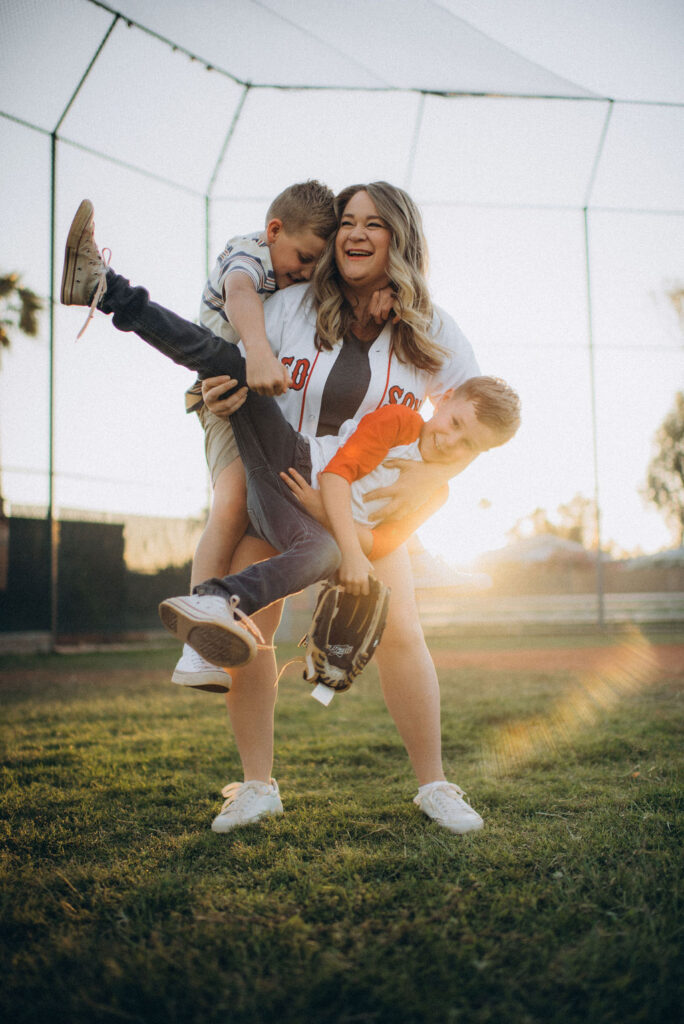 mom and her sons play baseball at a Phoenix, AZ baseball field for their candid storytelling session