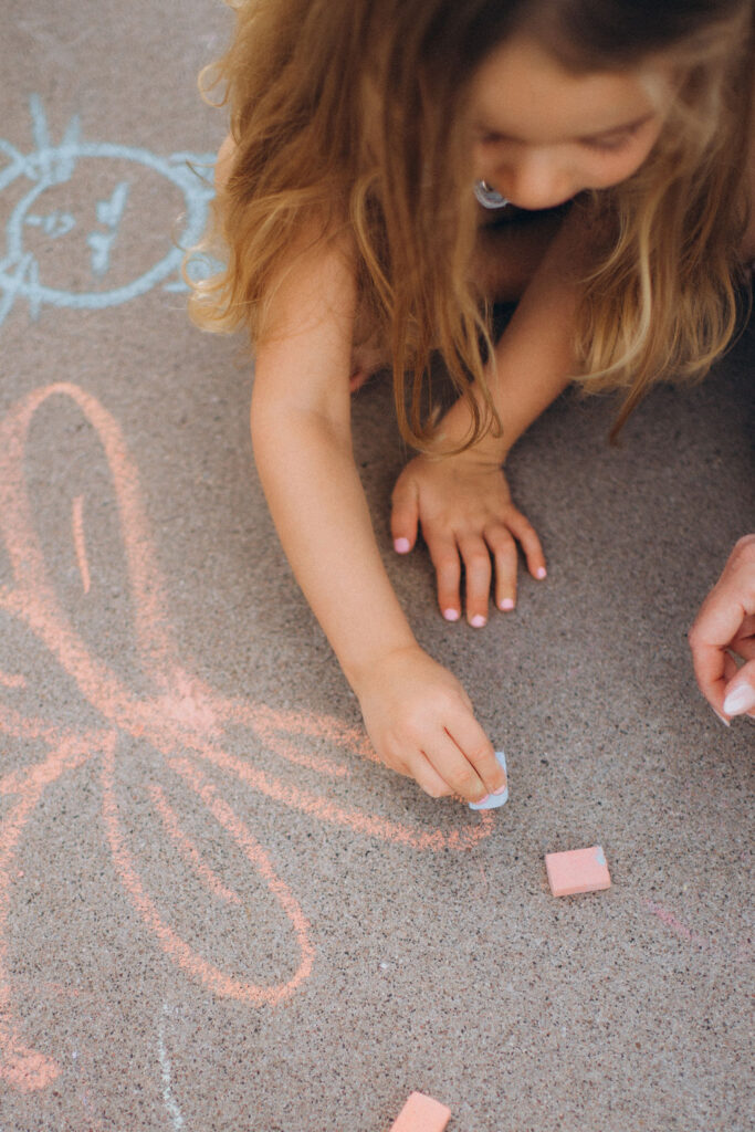little girl drawing with chalk on her Phoenix home driveway